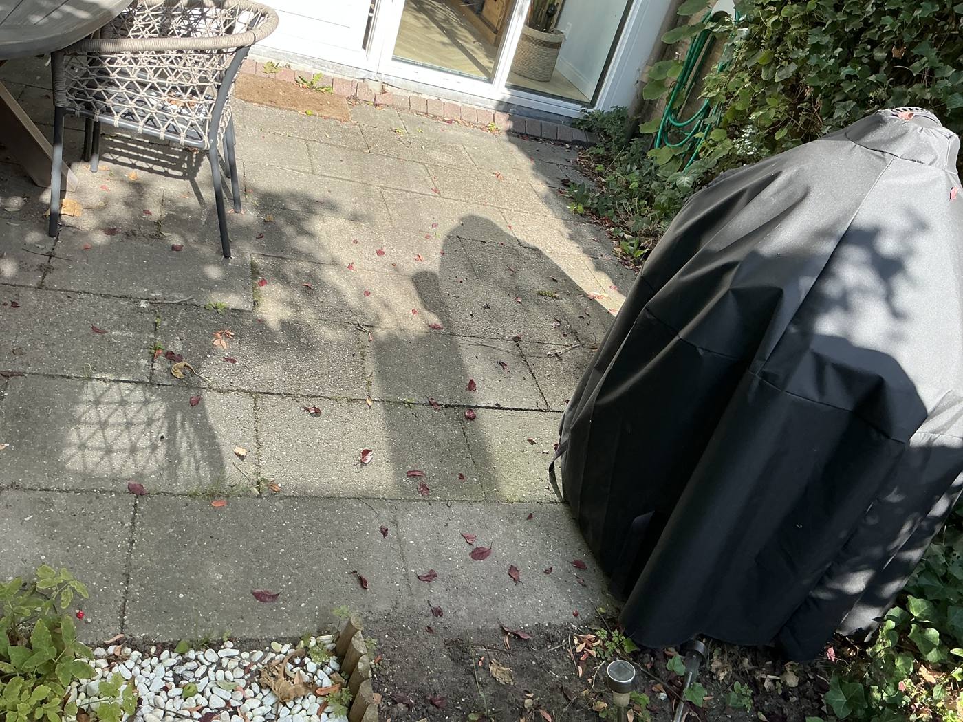 Verouderde bestrating in de tuin voor de tuinrenovatie in Delft